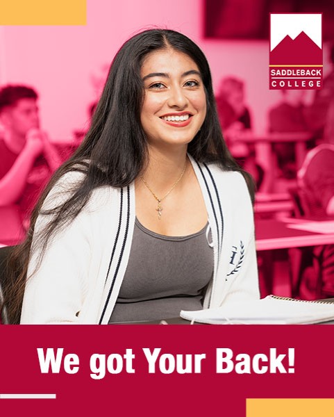 Female student sitting in class smiling at the camera. We got your Back!