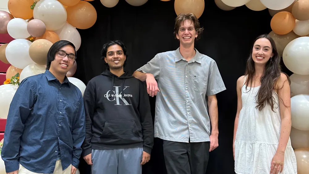 Four students standing in front of a balloon archway to celebrate being the 2025 Chemistry Scholarhip Recipients.