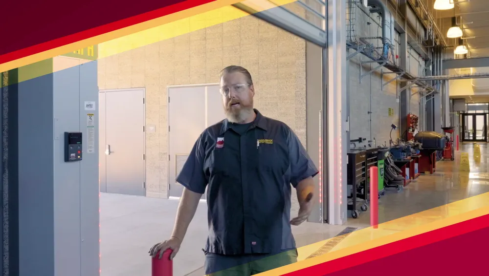 Male Automotive instructor being interviewed in the automotive bay.
