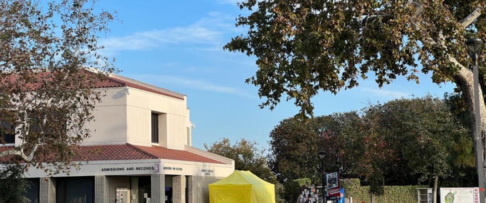 Red chairs on the quad with the yellow student development tent in the background as well as the Admissions & Records office.