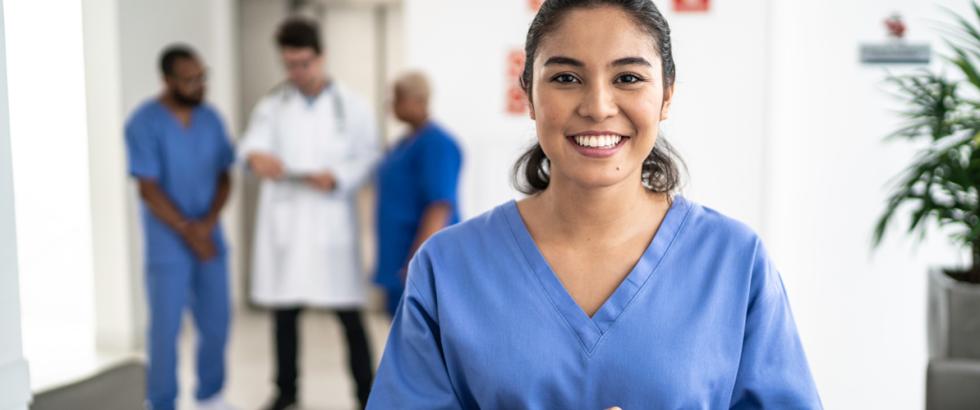 Medical professional in blue scrubs smiling at patient