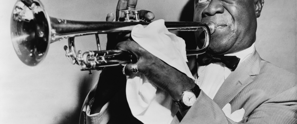Black Jazz musician Louis Armstrong playing the trumpet