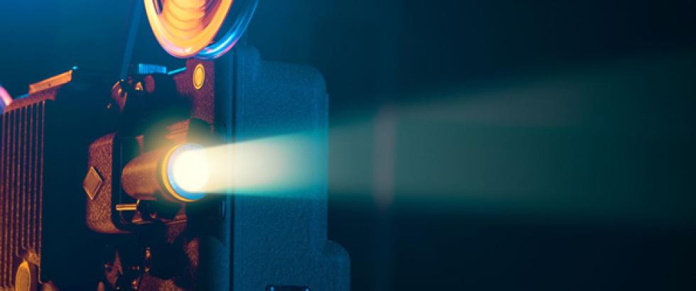 Image of an old school projector projecting a movie