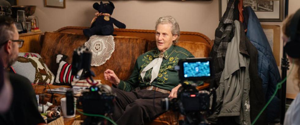 Temple Grandin sits on their couch being interviewed for the documentary An Open Door