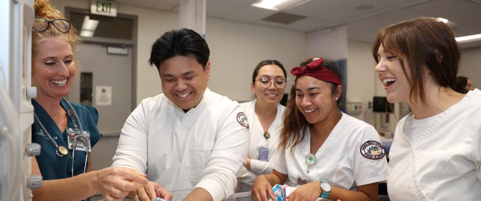 Students working on an infant medical dummy in a lab.