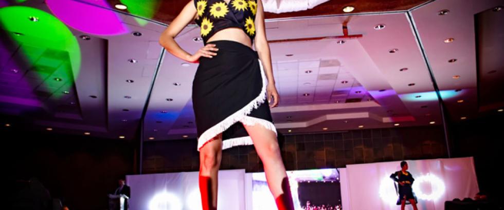 A model posing at the end of the runway at a fashion show