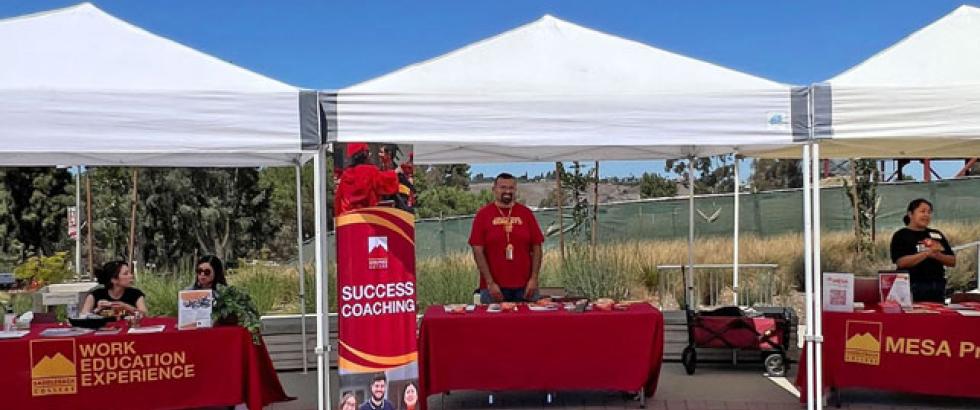 Three tables under white canopies at with Saddleback reps at the involvement fair