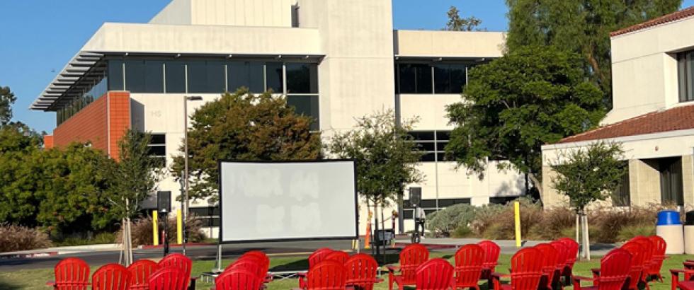 Red chairs lined up on the Saddleback Quad facing an outdoor movie screen