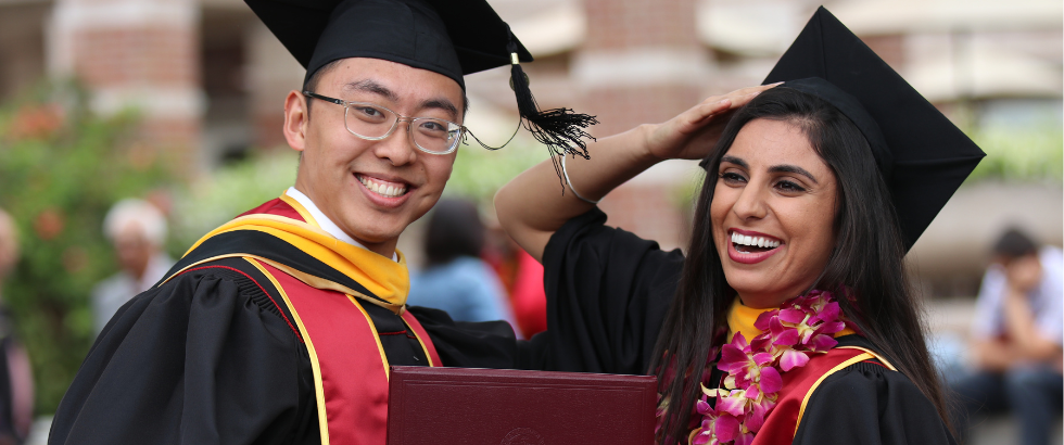 male and female in graduation cap and gown, holding diploma