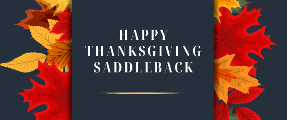 the words happy thanksgiving saddleback on a dark grey background with leaves