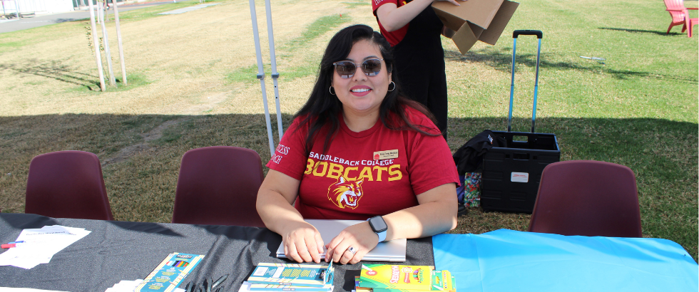 female saddleback college staff sitting at a table outdoors