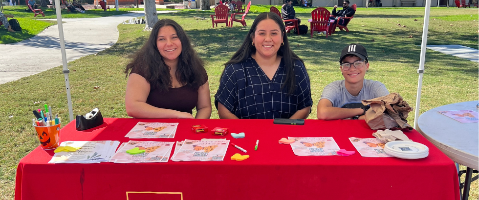 image of three students at a table with a red table cloth