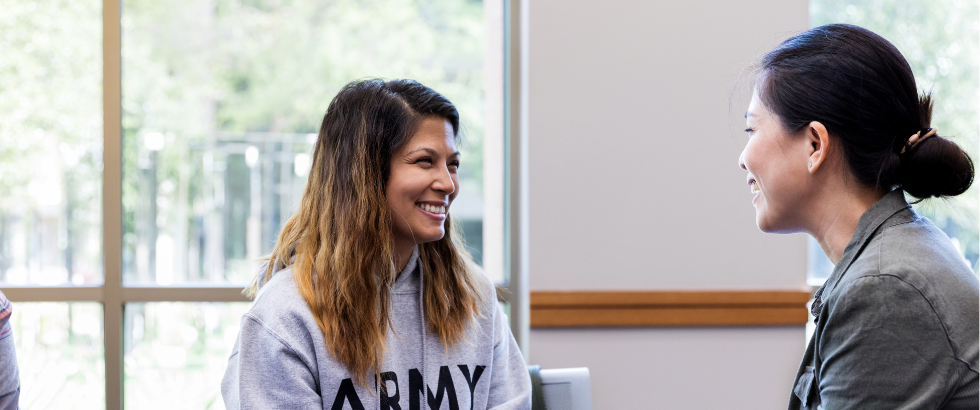 mid adult female army veteran smiles with relief when another mid adult female validates her