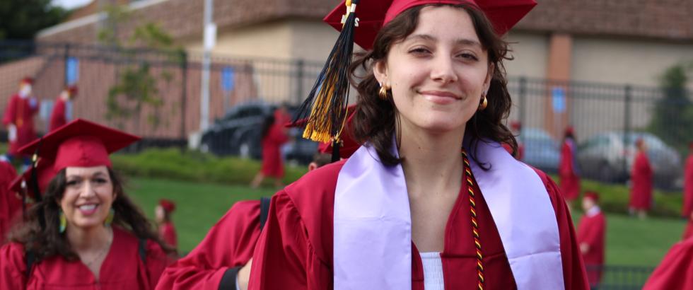female student walking during commencement with a lavender stole