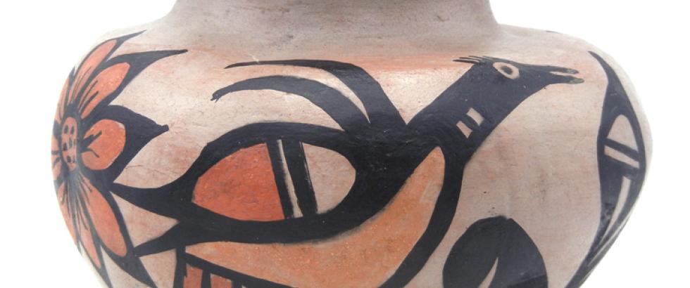 A hand-painted ceramic pot featuring bold black and red geometric and natural motifs on a light clay background. The design includes stylized birds, flowers, and abstract shapes encircling the vessel. The pot has a rounded body, narrow neck, and flared rim, showcasing traditional craftsmanship.