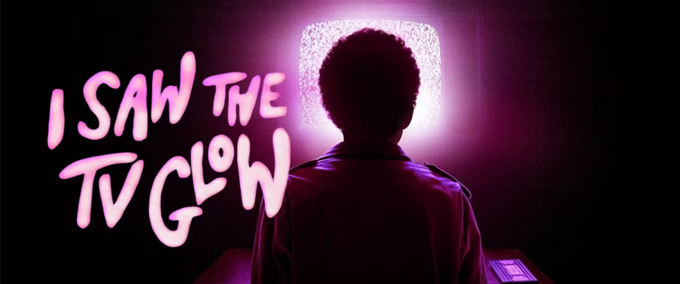 A silhouetted person stands facing a bright, static-filled television screen in a dark room. Neon-style text on the left reads, “I SAW THE TV GLOW.” A small device rests on a table beneath the glowing screen.