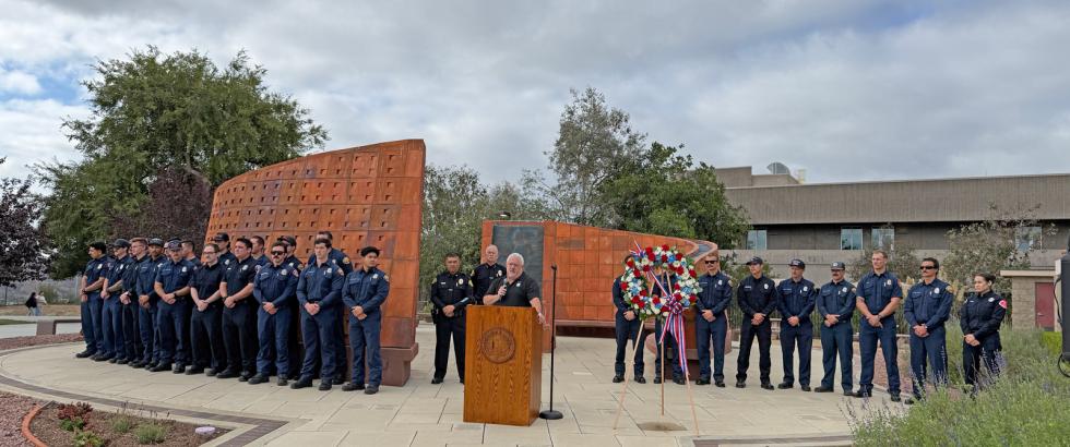 Members of the Saddleback College EMT class are gathered in front of the Saddleback College Veterans Memorial for a 9/11 observance event.
