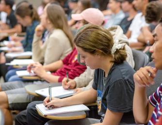 Student taking notes during a lecture