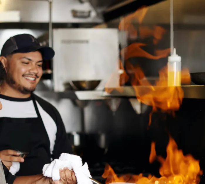 Student cooking with skillet on fire