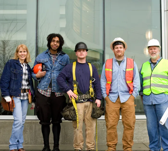 A group of construction workers standing in front of a building.