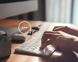 Hands typing on a keyboard with word bubbles appearing