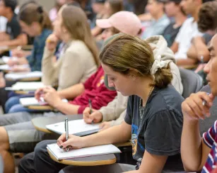 Student taking notes during a lecture