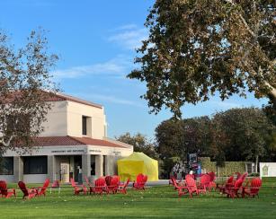 Red chairs on the quad with the yellow student development tent in the background as well as the Admissions & Records office.