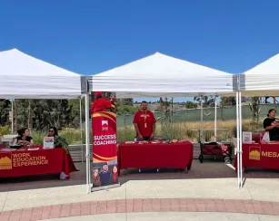 Three tables under white canopies at with Saddleback reps at the involvement fair