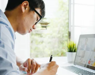 Young male using laptop talk to about plan in video call meeting while work from home at living room