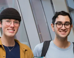 two students standing in front of a window