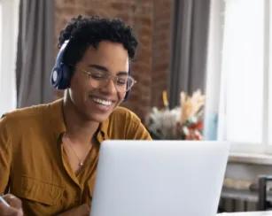 cheerful college student in earphones attending virtual class