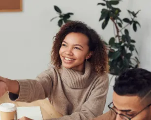 young woman shaking hands with someone you cannot see 