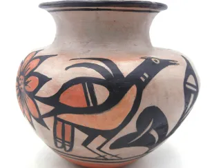 A hand-painted ceramic pot featuring bold black and red geometric and natural motifs on a light clay background. The design includes stylized birds, flowers, and abstract shapes encircling the vessel. The pot has a rounded body, narrow neck, and flared rim, showcasing traditional craftsmanship.