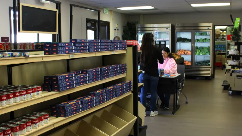 student checking out with another student in a grocery store setting