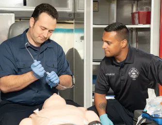 Saddleback Students in EMT training with healthcare manikin