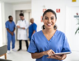 Medical professional in blue scrubs smiling at patient