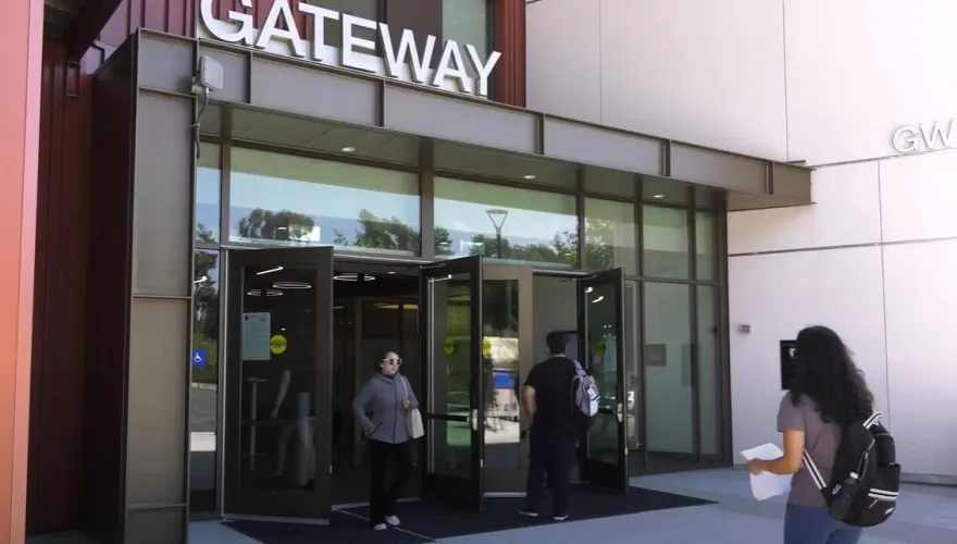 Students walking in and out of the Gateway building entrance.